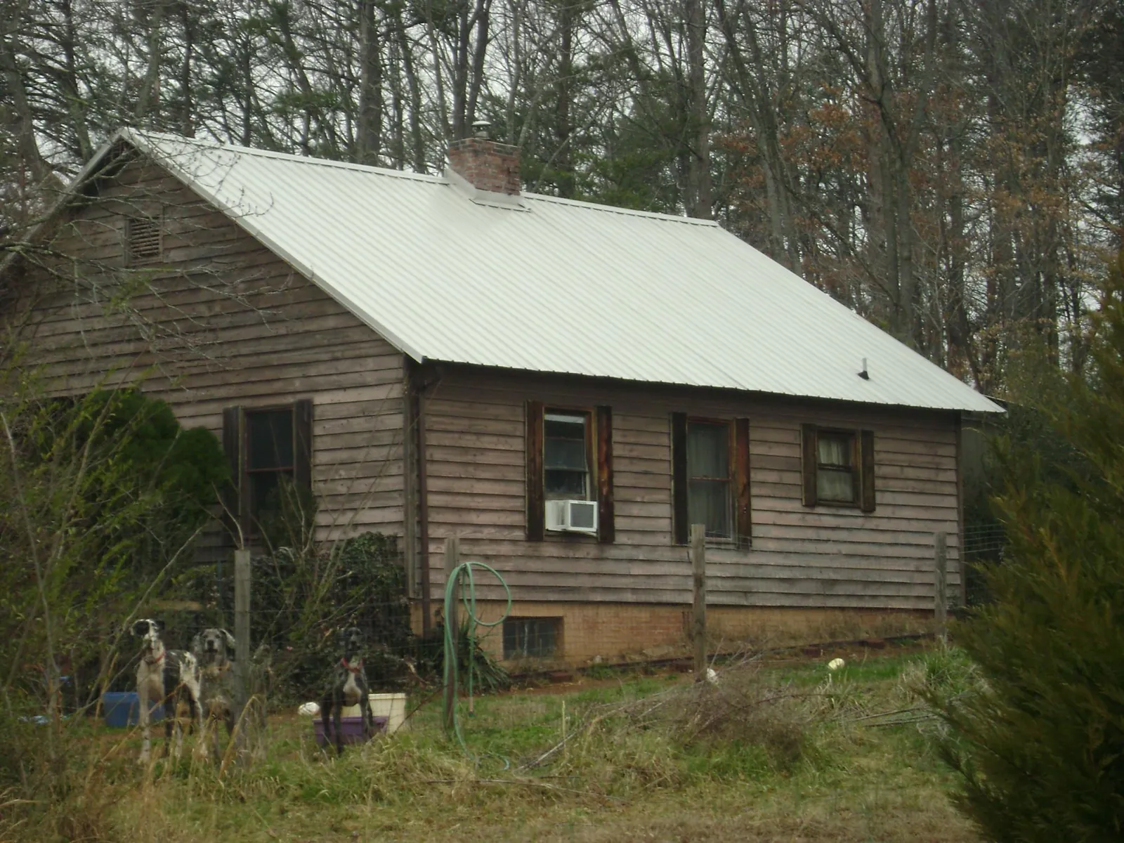 White metal roof on an old wood sided farmhouse, from a Metal Roof Installation job in Saint Francis